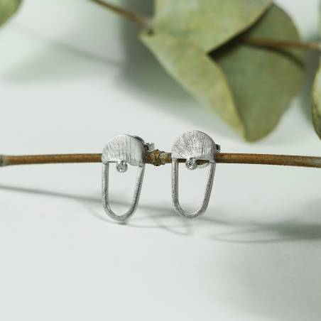 Pendientes pequeños en forma ovalada en plata de ley con acabado rodio y un diamante
