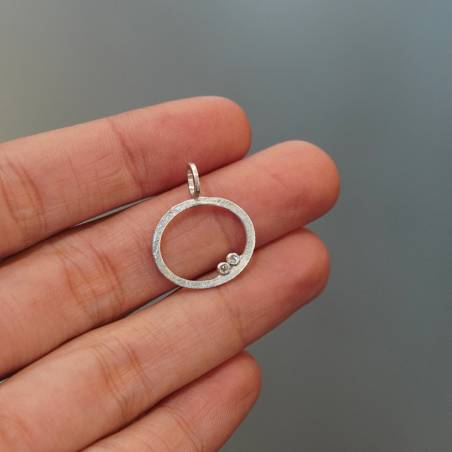 Colgante de diseño circular hecho en plata de primera ley con acabado mate rodio.