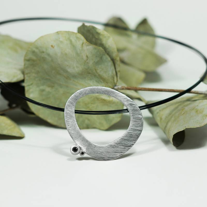 Sterling silver pendant with a matte finish and two black diamonds